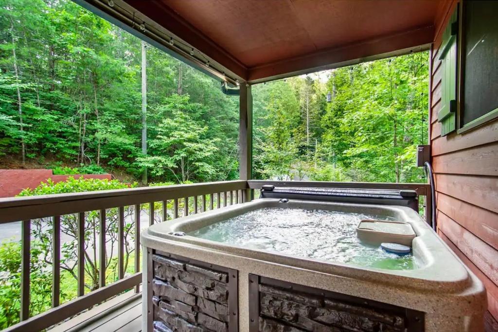 a jacuzzi tub on a screened in porch at Black Bear Lookout by Avada Properties in Townsend