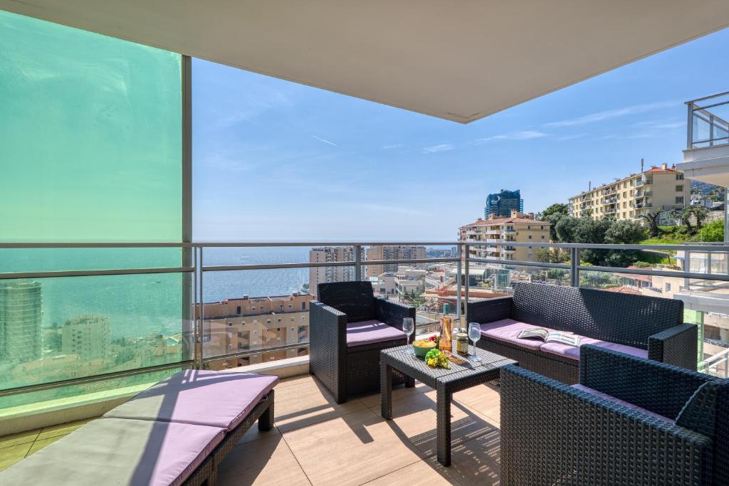 un balcon avec des chaises et une table sur un immeuble dans l'établissement Krystal Palace - Splendid Sea View - Happy Rentals, à Beausoleil