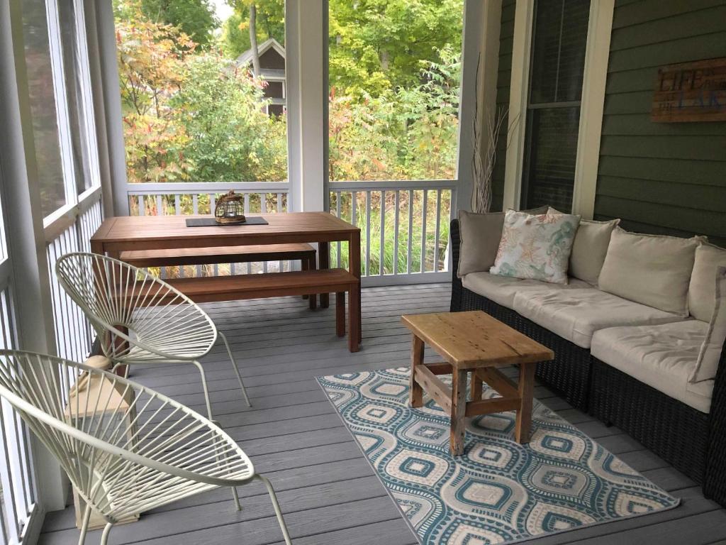 a porch with a couch and a table and chairs at The Chorus Frog - 8 Hollow in Cherry Valley