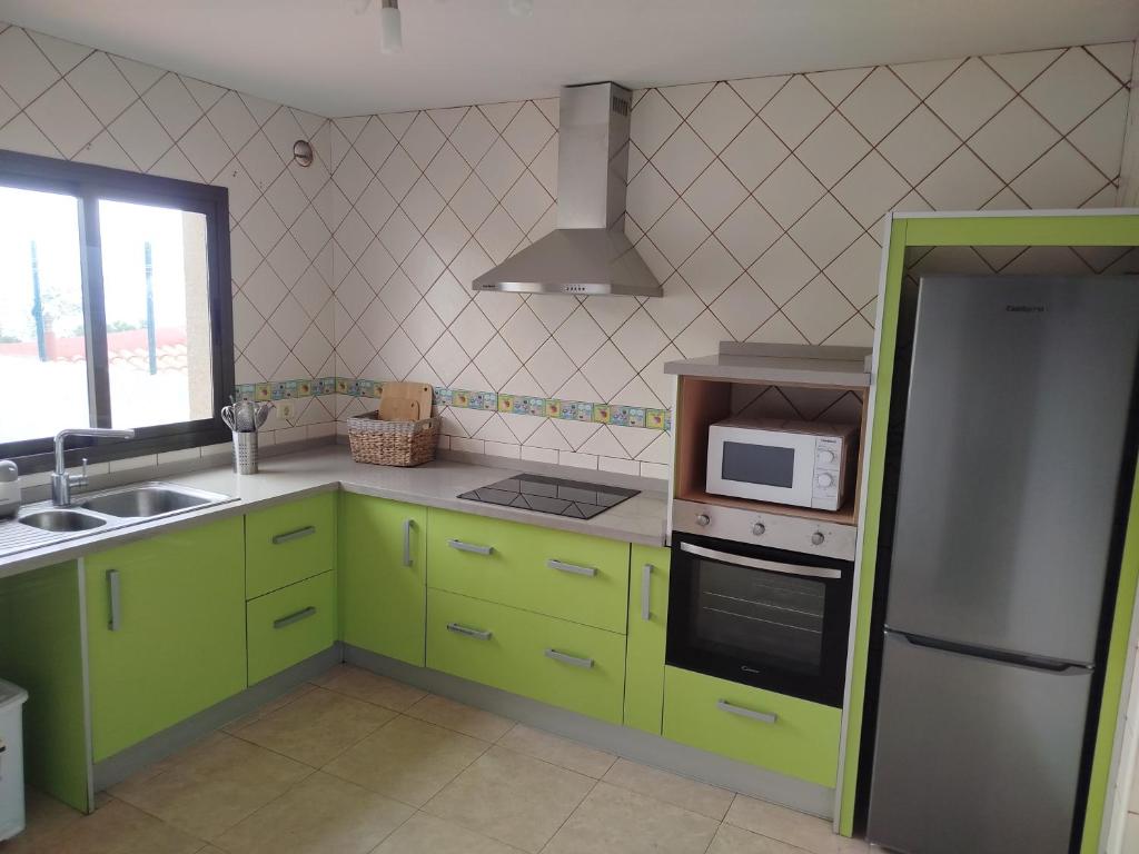 una cucina con armadi verde lime e forno a microonde di Vivienda VACACIONAL LA PASADA a Las Casas