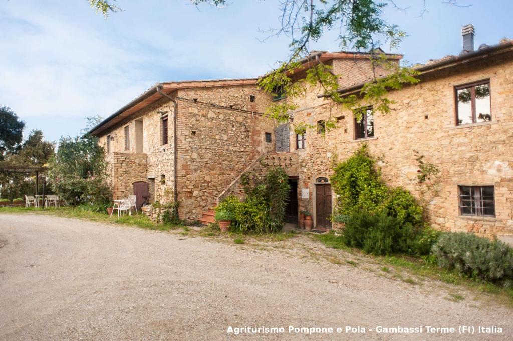 an old brick building on a dirt road at Agriturismo Pompone e Pola in Gambassi Terme