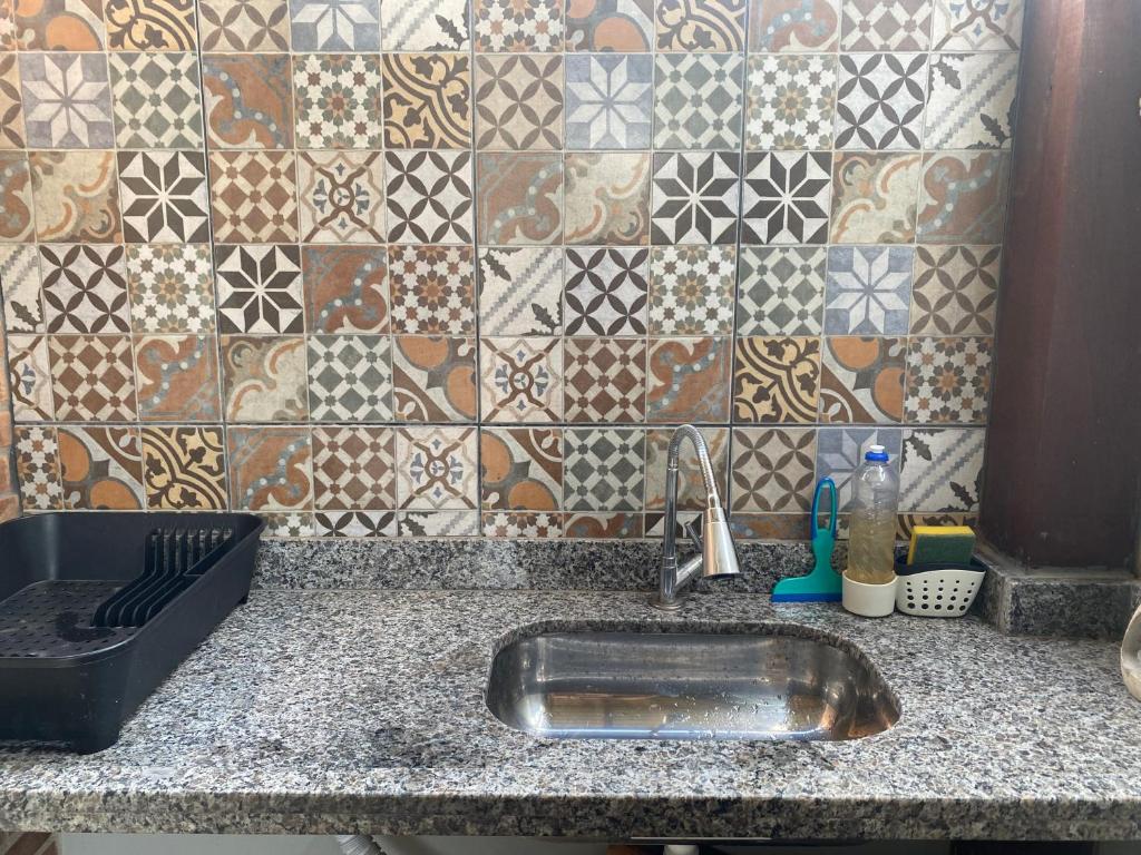 um balcão de cozinha com um lavatório e uma parede em azulejo em Casa 2 Suites, Niterói Região Oceanica em Niterói