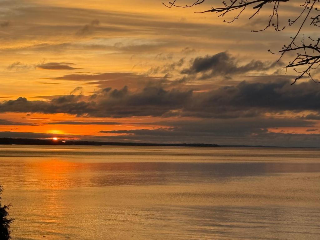 a sunset over a body of water at Maison sur la plage in Chambord
