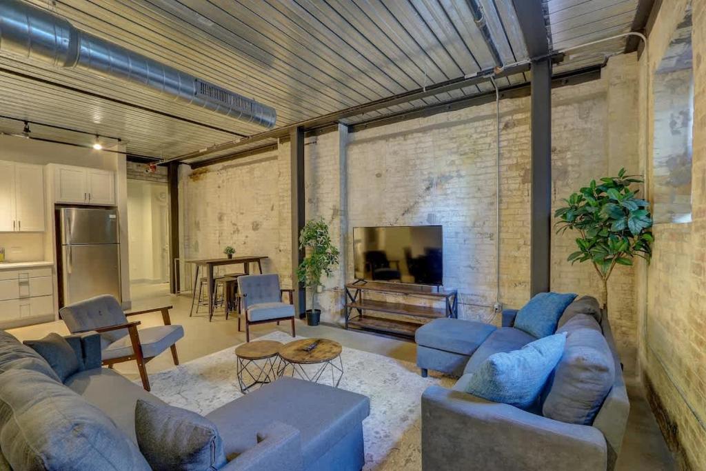 a living room with blue couches and a tv at Spotless 1BD near Historic Pabst Brewery - Fiserv in Milwaukee