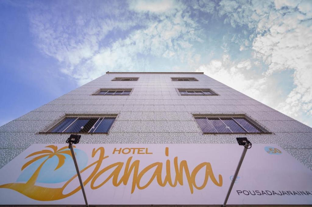 ein hohes weißes Gebäude mit einem Hotel Santa Ana Schild in der Unterkunft Hotel Janaína in Porto Belo