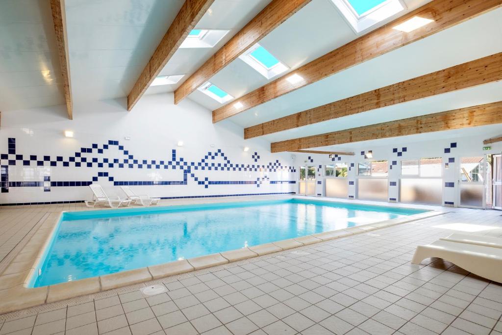 - une grande piscine dans une grande pièce dotée de plafonds en bois dans l'établissement Camping les mizottes, à Saint-Michel-en-lʼHerm