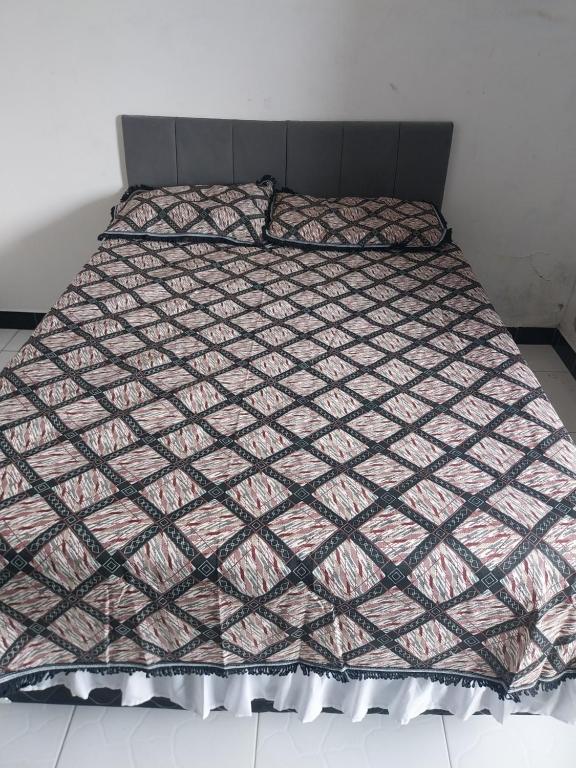 a bed with a comforter on top of it at à 5 minutos do Parque do Povo in Campina Grande