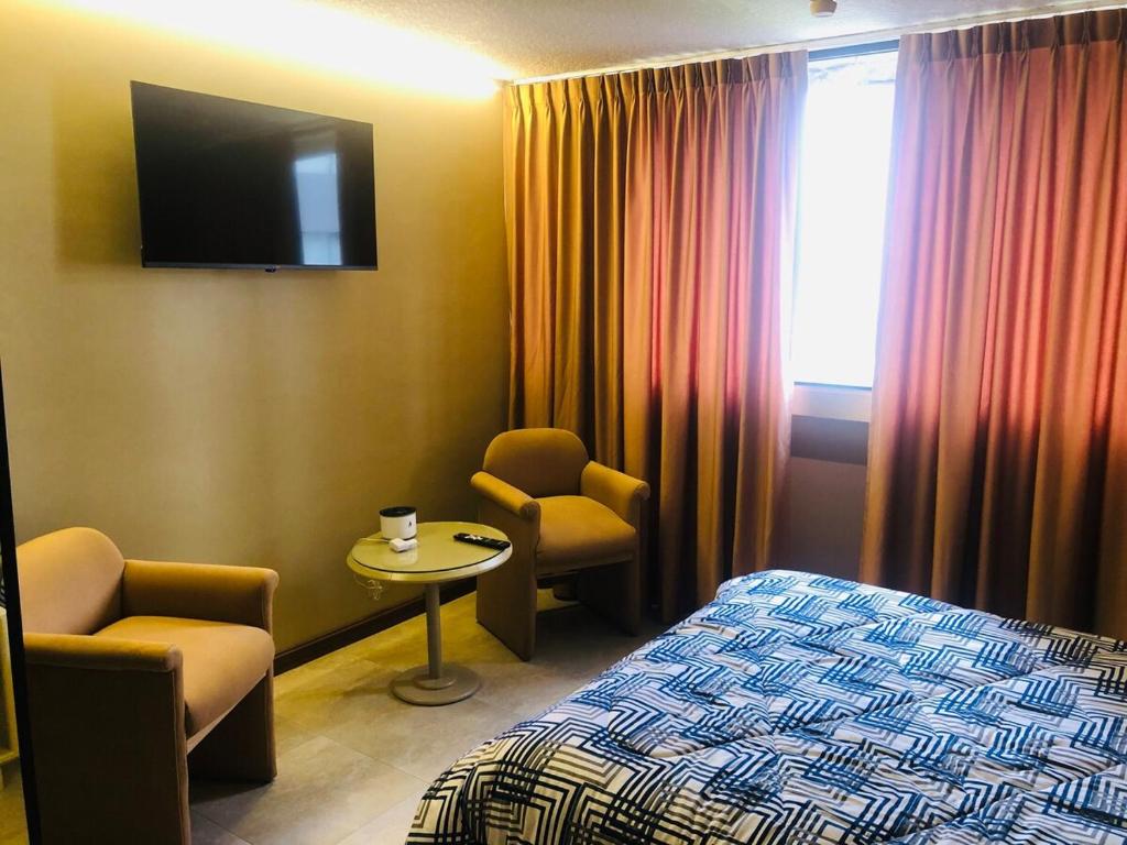 a hotel room with a bed and a chair and a tv at Luxurious Akros 526 Suite in Huamboya