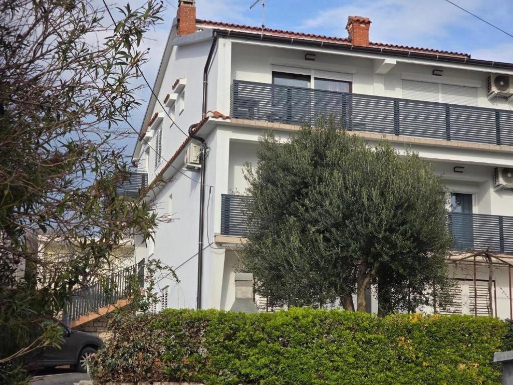 un edificio bianco con persiane nere di Apartments with parking space Palit, Rab - 4983 a Rab