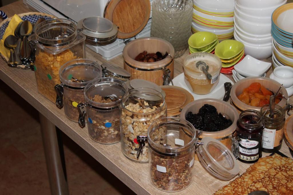 a table with jars of food and other items on it at Hotel Bristol in Chalons en Champagne