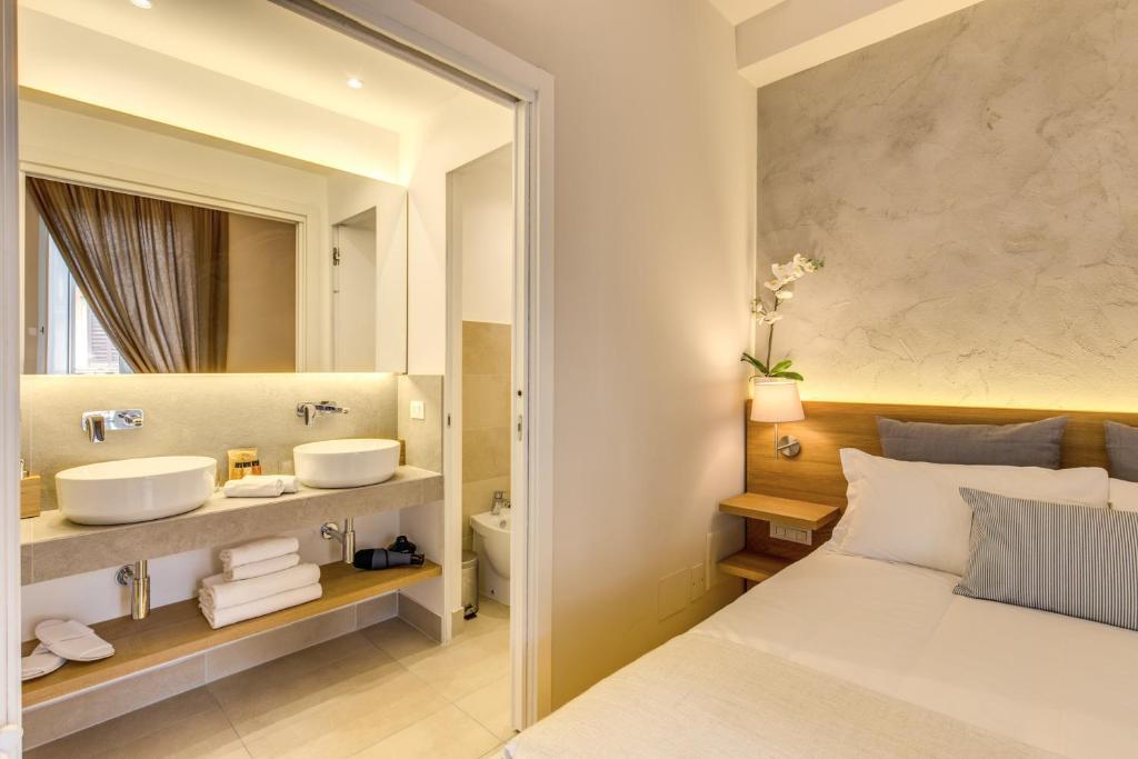 a bedroom with a bed and a sink and a mirror at The Spanish Suite Campo de' Fiori in Rome