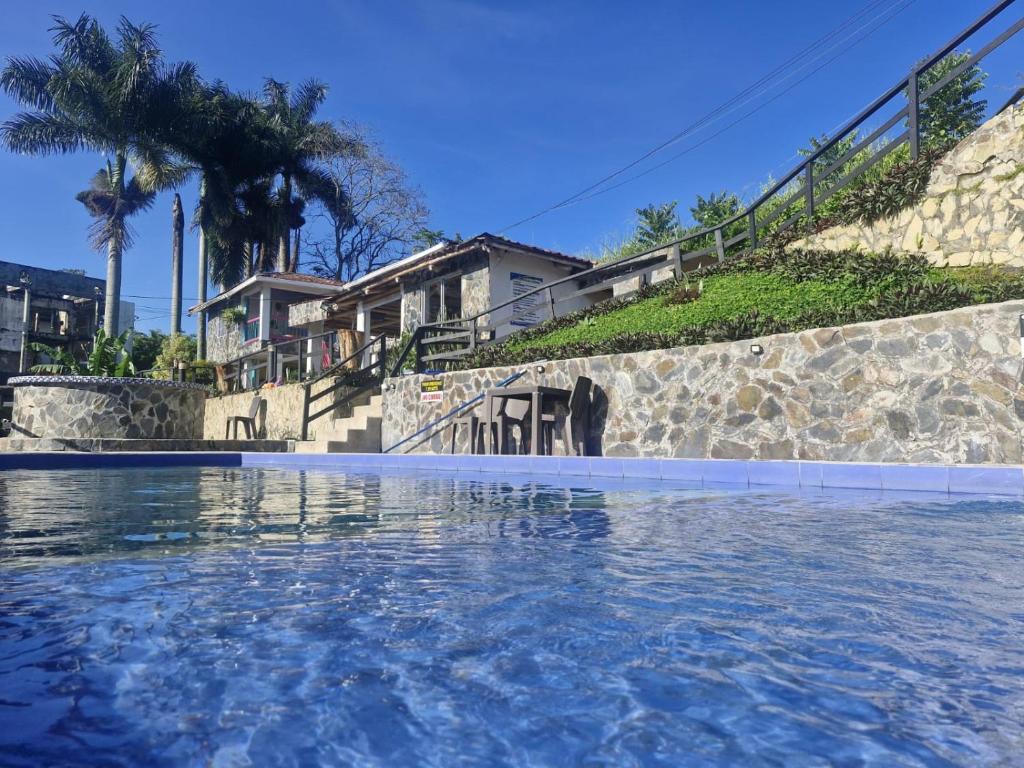 a swimming pool in front of a house at Iraka Campestre Quindio in El Edén