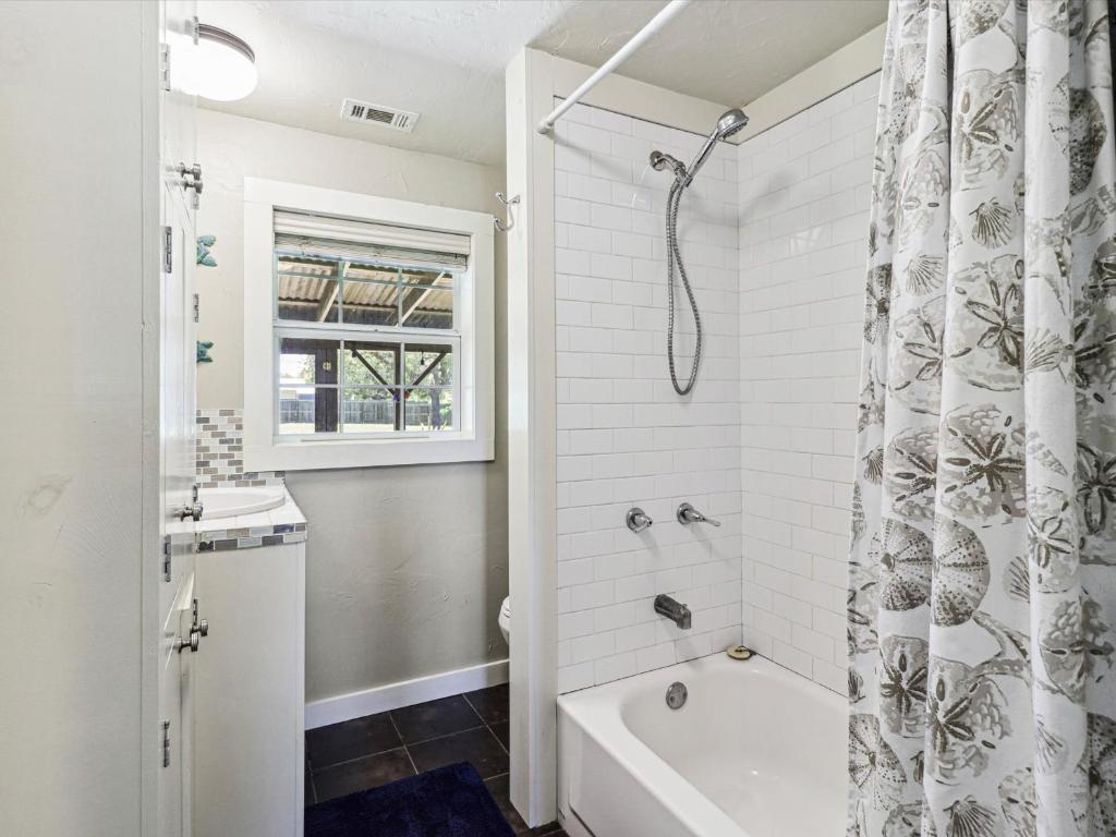 a white bathroom with a tub and a shower at Wahini Wave AP761 in Aransas Pass