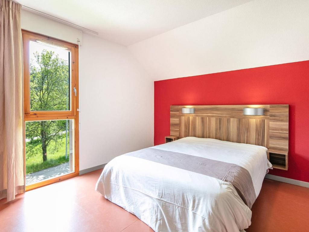 a bedroom with a large bed with a red wall at Chalet with shuttle bus in Gresse in Gresse-en-Vercors