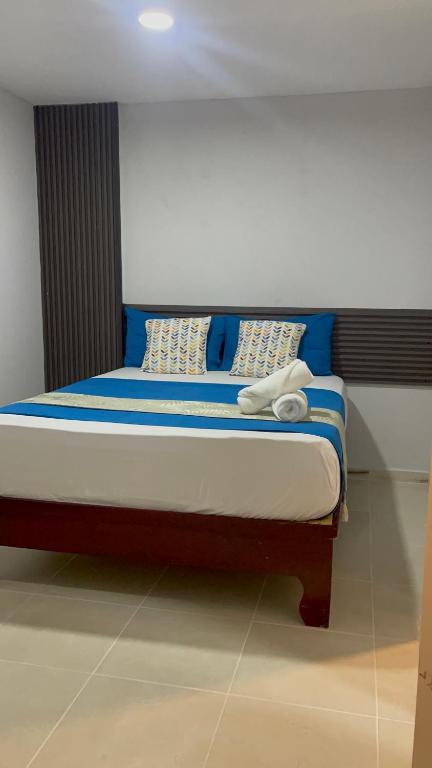 a bed with blue and white pillows on it at JM 257 Gh in Santo Domingo