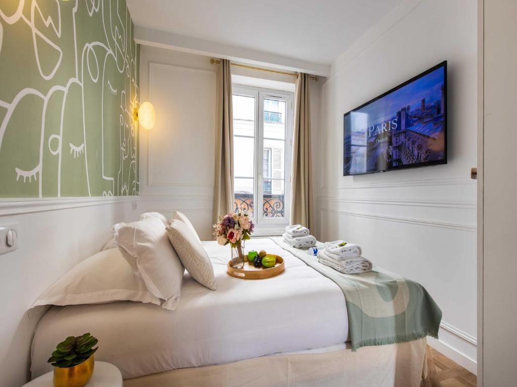 une chambre avec un grand lit blanc avec une fenêtre dans l'établissement Chic studio for 2 people - Pigalle Sacré-C ur, à Paris