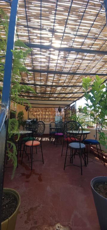 a patio with tables and chairs under a wooden ceiling at Center Medina in Fez