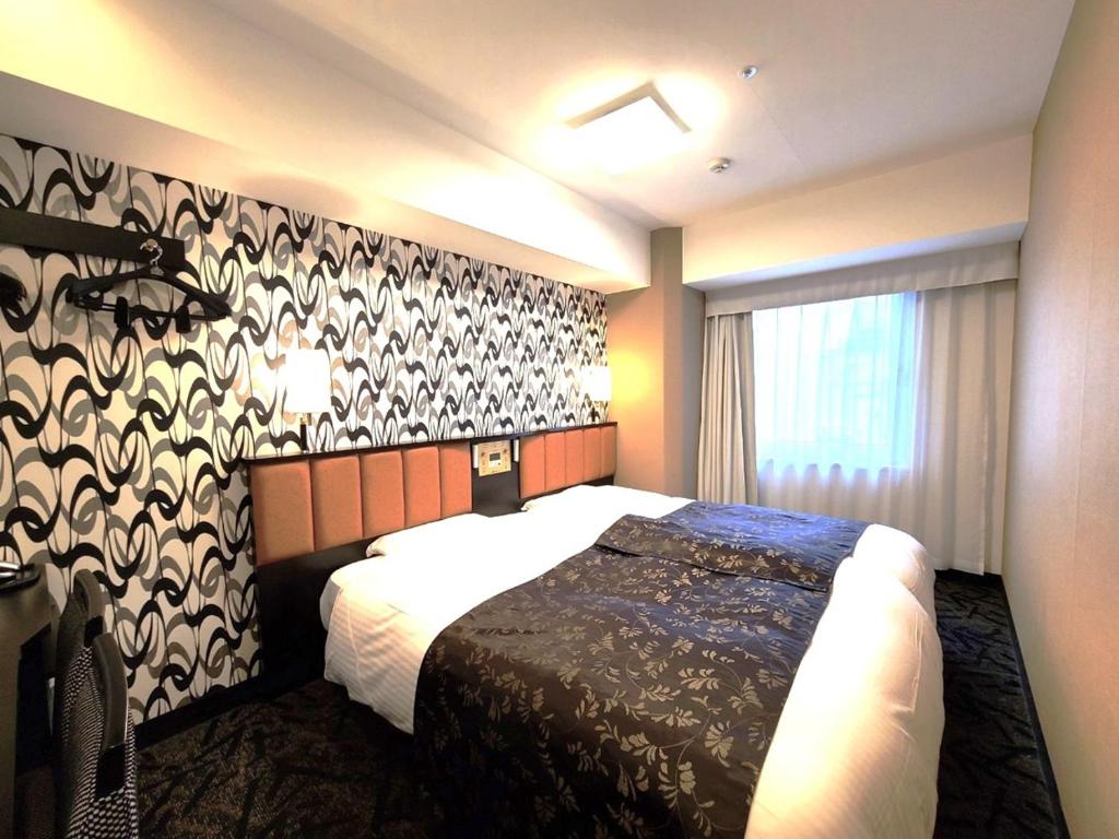 Postel nebo postele na pokoji v ubytování APA Hotel Nihombashi Bakuroyokoyama Ekimae