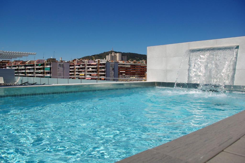a swimming pool with a fountain on top of a building at 08028 Apartments in Barcelona