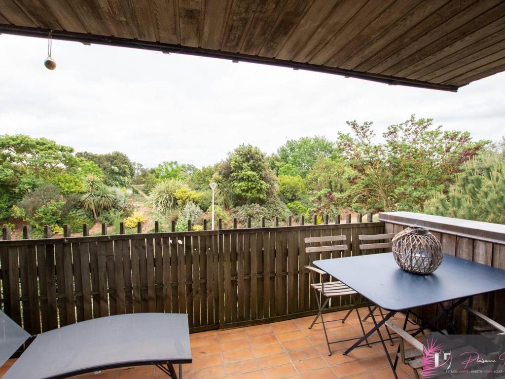 un patio avec une table et des chaises et une clôture dans l'établissement Charmant T2 à 50m de la plage avec balcon et wifi - FR-1-825-40, à La Rochelle