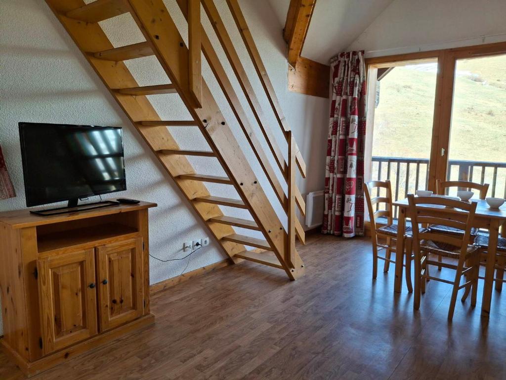 un salon avec une télévision et une table avec des chaises dans l'établissement T2 confort 4 pers, balcon ensoleillé, proche pistes - FR-1-807-134, à Saint-François-Longchamp