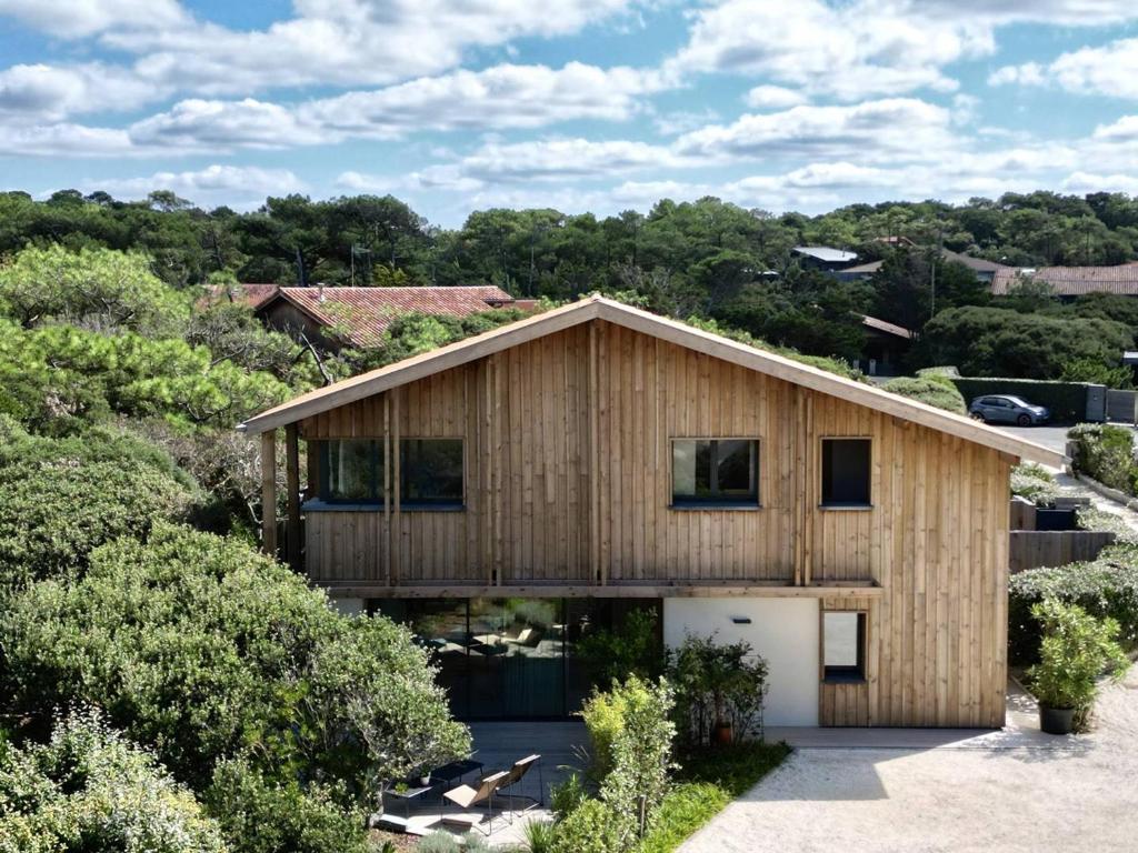 une maison en bois avec un garage dans l'établissement Luxe Triplex bord de mer à Hossegor - FR-1-791-40, à Soorts-Hossegor