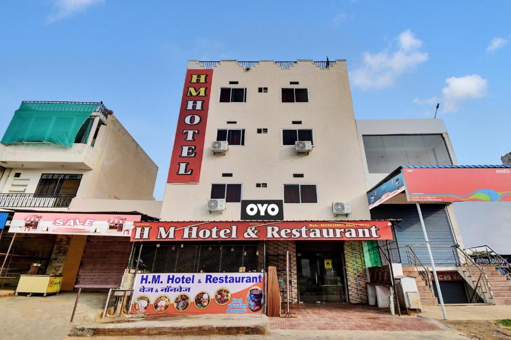 a building with a hotel and a sign in front of it at Hotel O HM & Restaurant in Begās