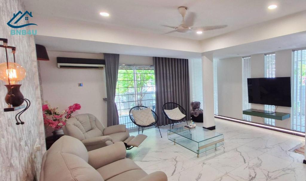 a living room with couches and a flat screen tv at Cangkat Delima Gathering House by BNB4U in Jelutong
