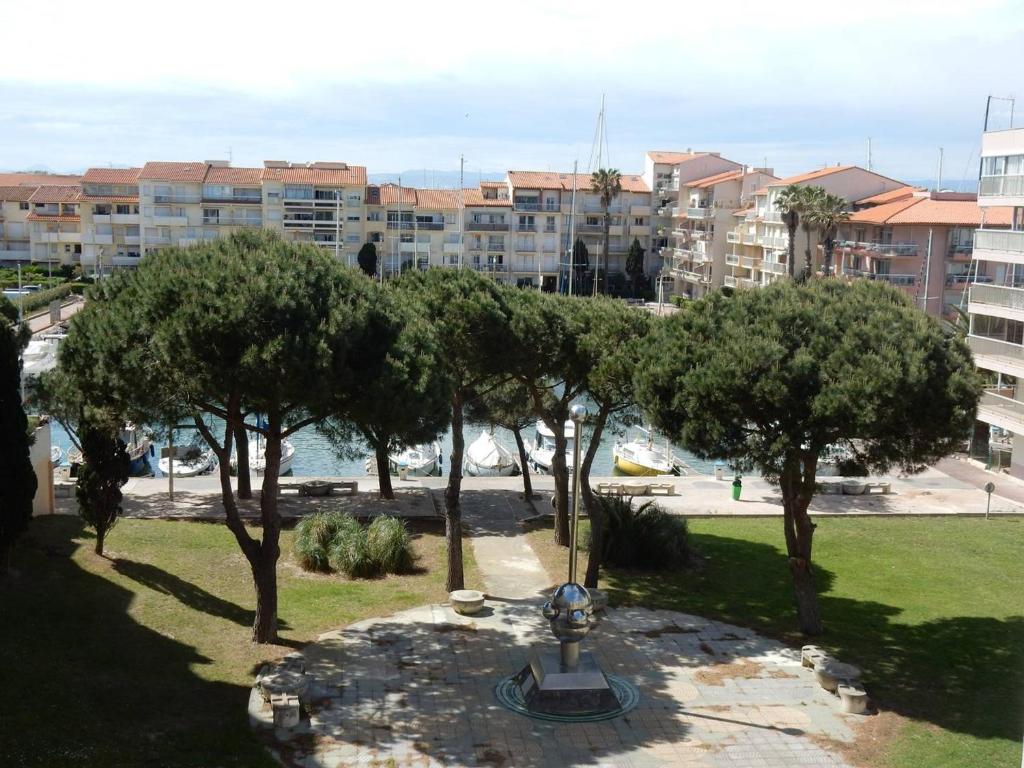 un parc avec des arbres et une fontaine dans une ville dans l'établissement Studio Cabine 2* avec Parking, Proche Plage - FR-1-750-111, à Canet