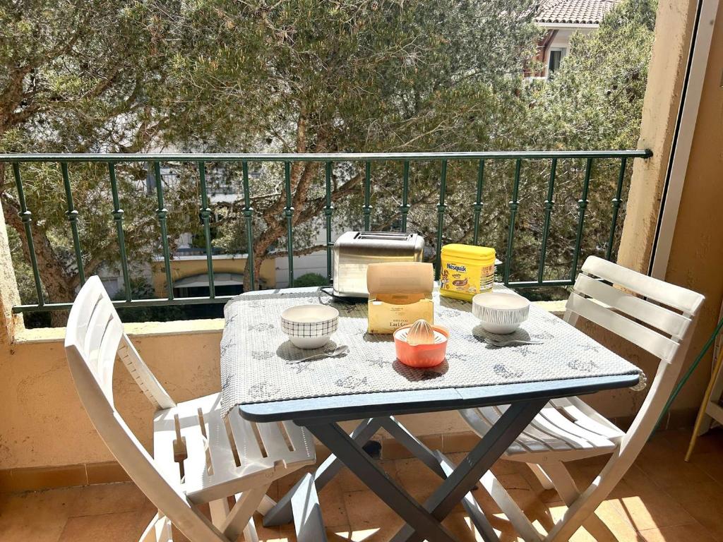 une table et deux chaises sur un balcon dans l'établissement Studio Mezzanine à Saint-Aygulf, Proche Plage et Commerces - FR-1-226A-207, à Fréjus
