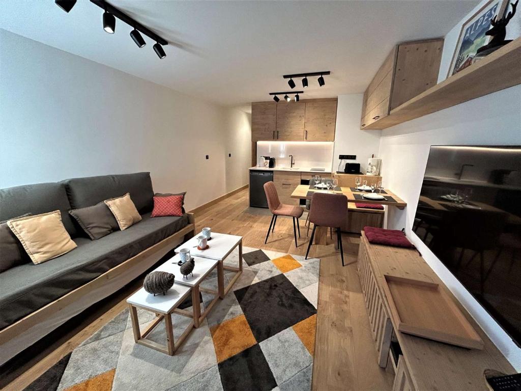 un salon avec un canapé et une table dans l'établissement Appartement rénové Méribel, proche pistes, fibre incluse - FR-1-180-657, à Les Allues
