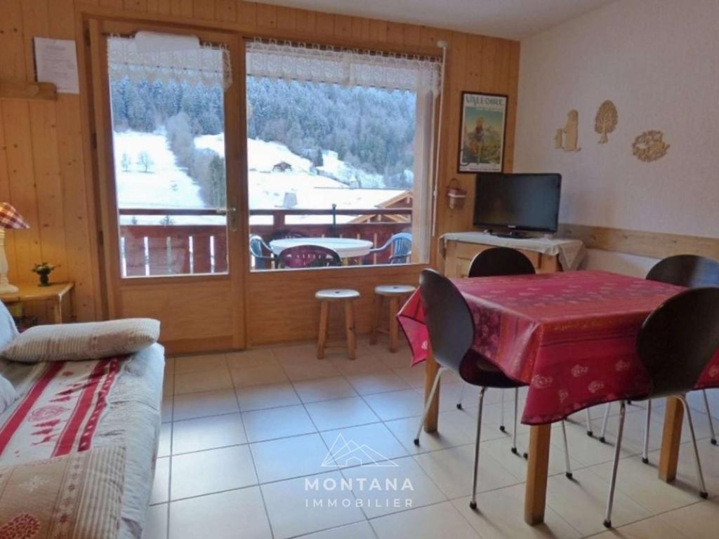 d'un salon avec une table et un balcon. dans l'établissement Confortable 2 pièces + coin nuit, 41m², 4 pers., proche remontées mécaniques - FR-1-458-221, au Grand-Bornand