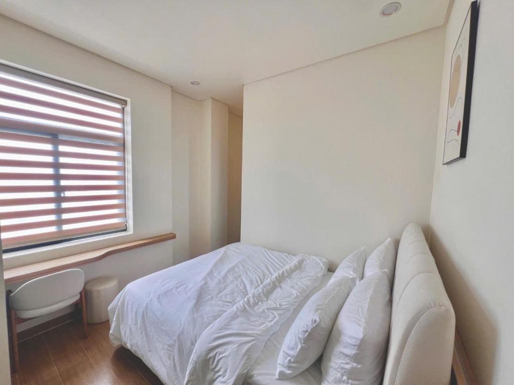 a bedroom with a white bed and a window at At De June 204 in Cu Lao Thu