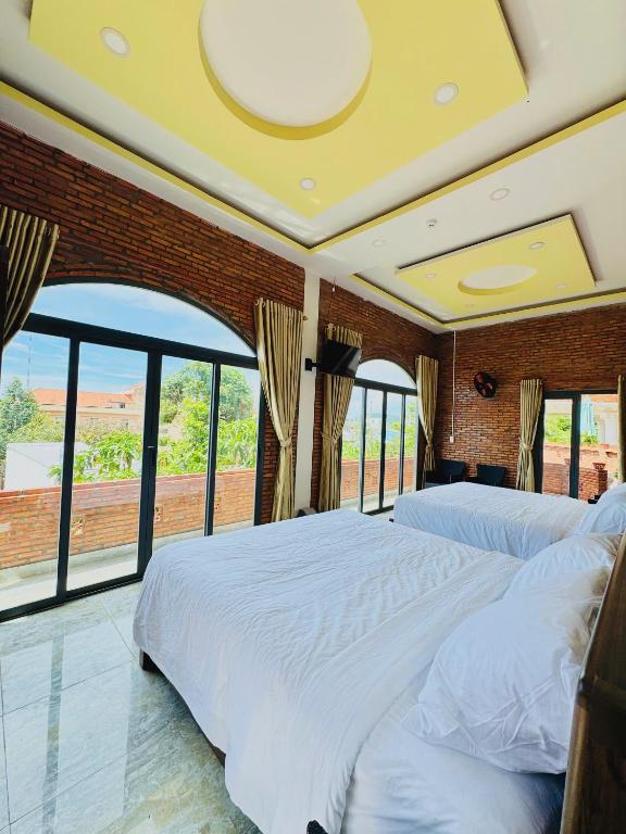 a bedroom with two beds and a large window at An Thới Ocean View - ẩn mình trên cao tầm nhìn ôm trọn biển in Phú Quốc