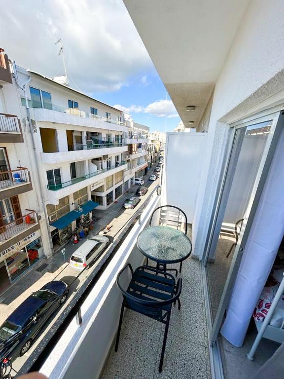 a balcony with a table and chairs and a street at Central Comfort Studio in Larnaca