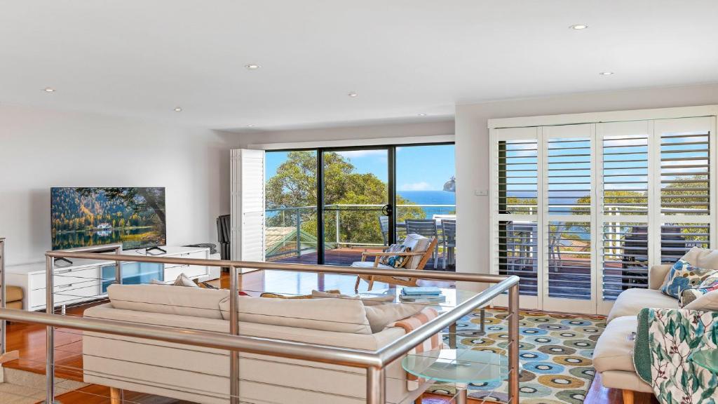 a living room with a view of the ocean at 'Headlands at Killcare' by HolidayCo in Killcare
