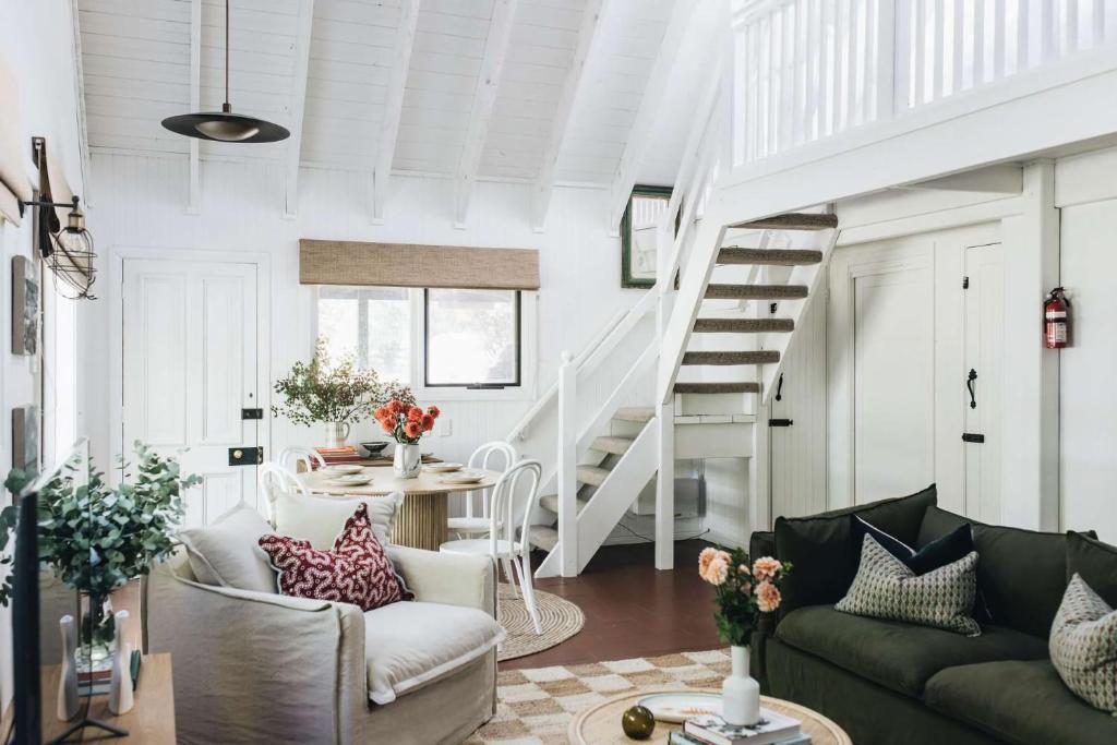 un soggiorno con un divano e una scala di Coromandel Cottage, Berrima a Berrima