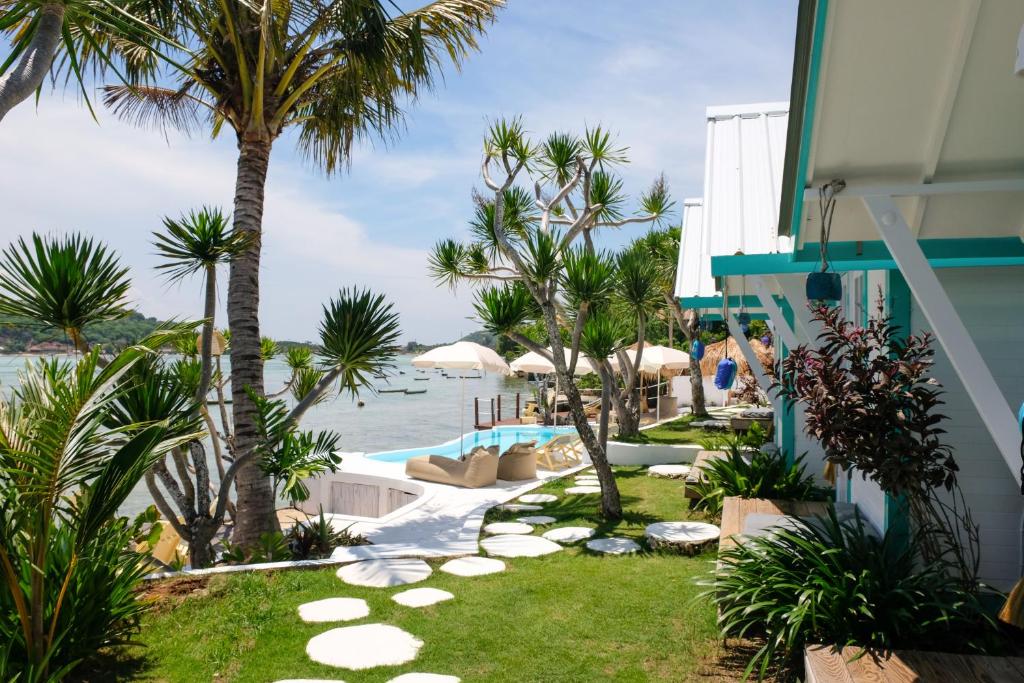 a resort yard with palm trees and a swimming pool at Le Pirate Beach Club Nusa Ceningan - Adults Only in Nusa Lembongan