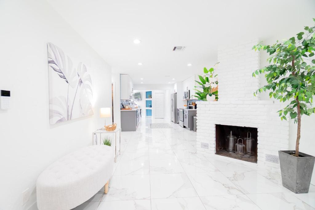 a white living room with a fireplace and a white couch at West Palm Beach Elegant 5BR with Hot Tub and Fire Pit Near Beach in West Palm Beach