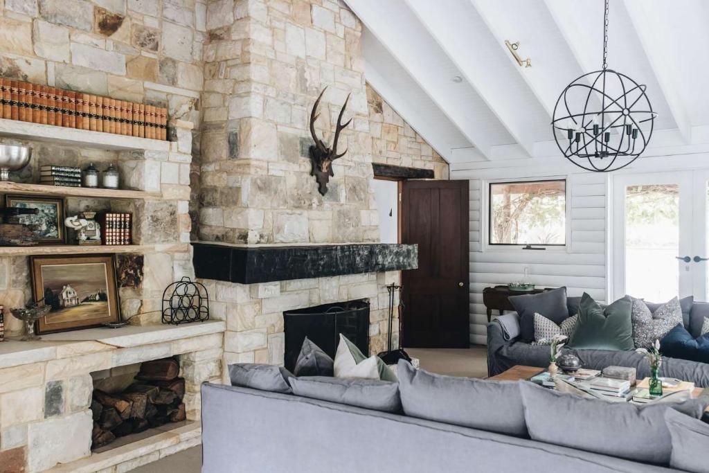 un soggiorno con camino in pietra e divani di Coromandel Homestead, Berrima a Berrima
