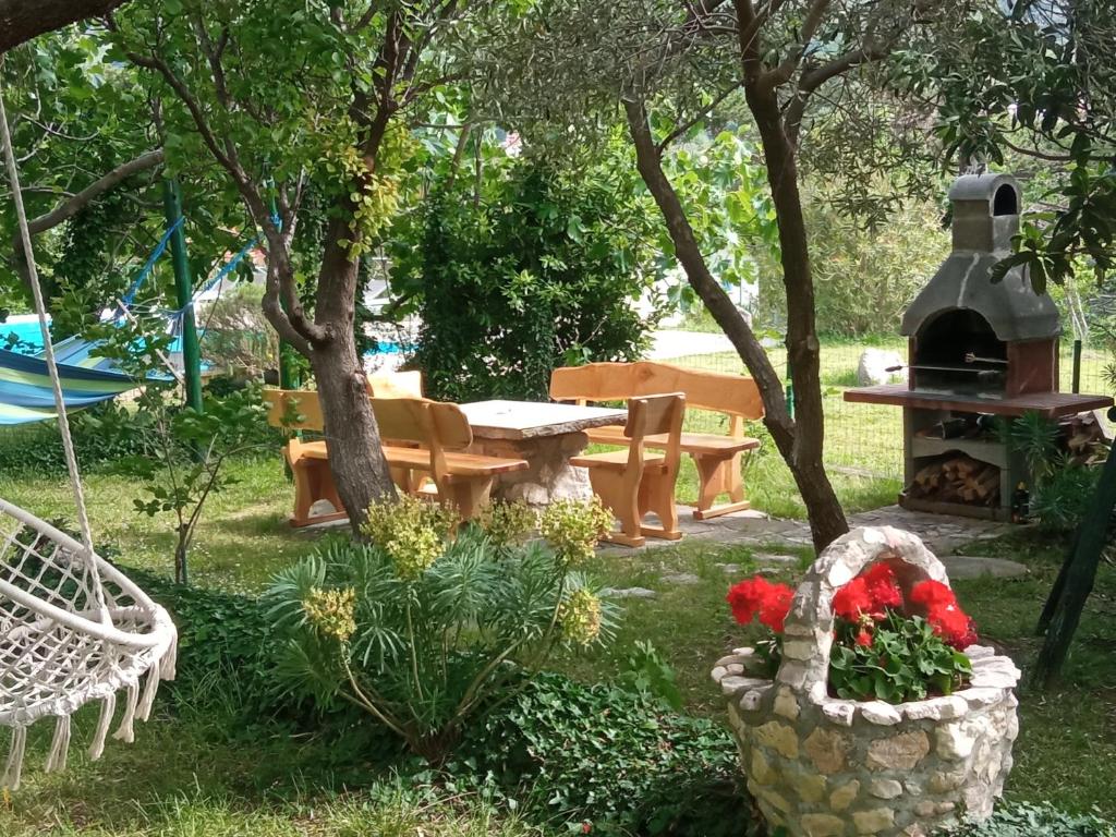 a garden with a picnic table and a basket of flowers at KATY&MLADEN in Baška
