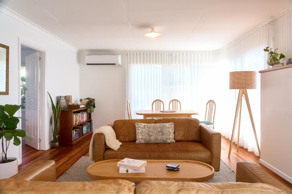 a living room with a brown couch and a table at Sweet Az in Bicheno