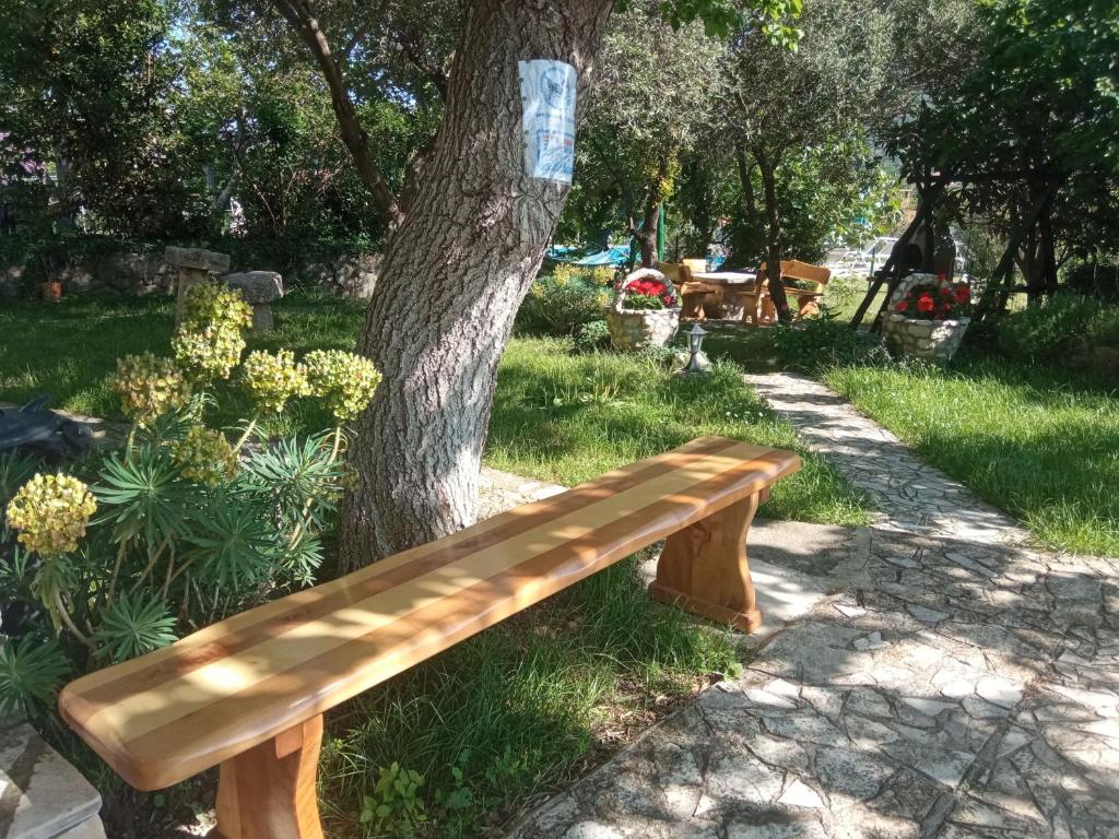 a wooden bench sitting next to a tree at KATY&MLADEN in Baška