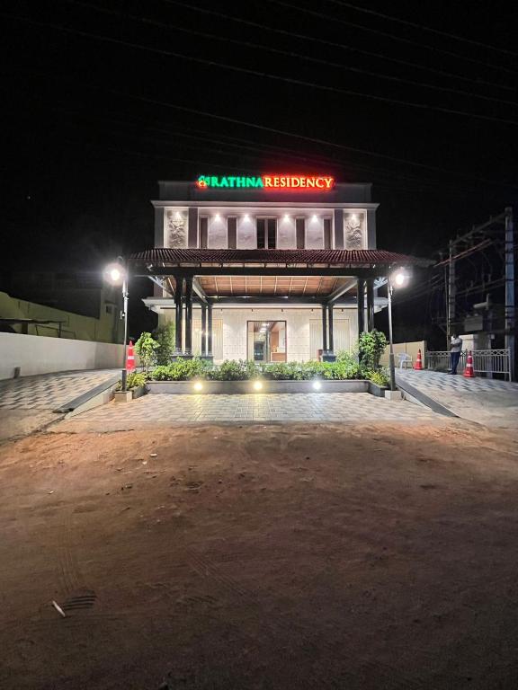 a building with a sign on it at night at Rathna Residency in Tiruppattūr