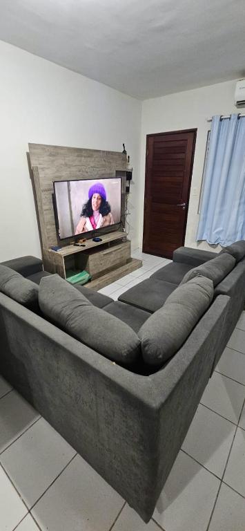 a large couch in a room with a flat screen tv at aconchegante e tranquila in Parnamirim