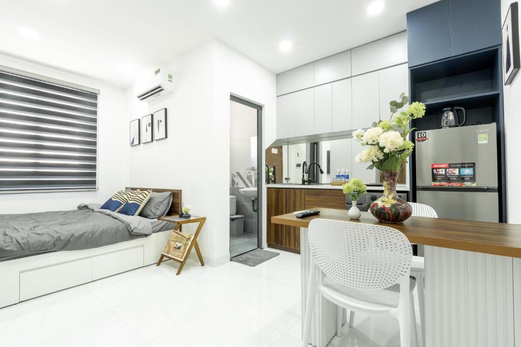 a bedroom and living room with a bed and a desk at Nhà Sài Gòn in Ho Chi Minh City