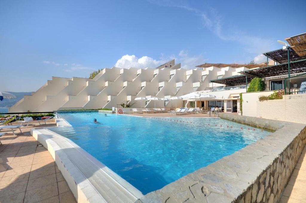 une grande piscine en face d'un bâtiment dans l'établissement Grand Hotel San Pietro, à Palinuro