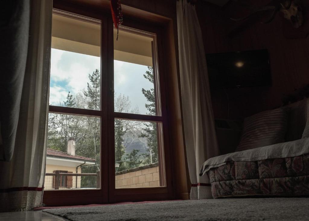 okno w sypialni z widokiem na dom w obiekcie La casa nel bosco w mieście Campo di Giove