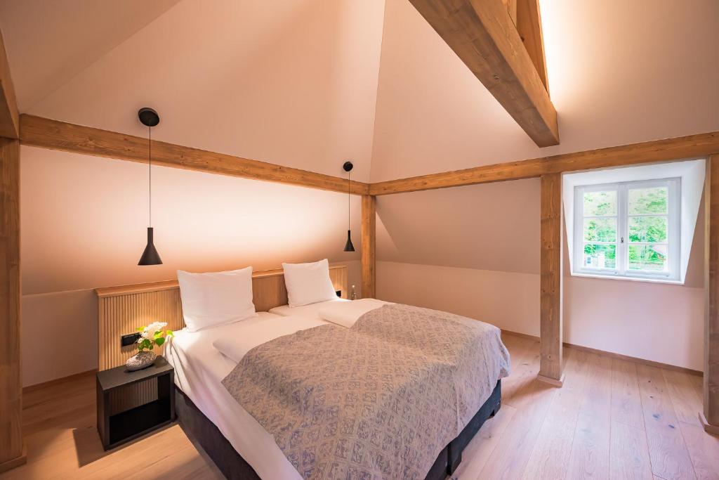 a bedroom with a large bed and a window at Gutshotel Menterschwaige in Munich