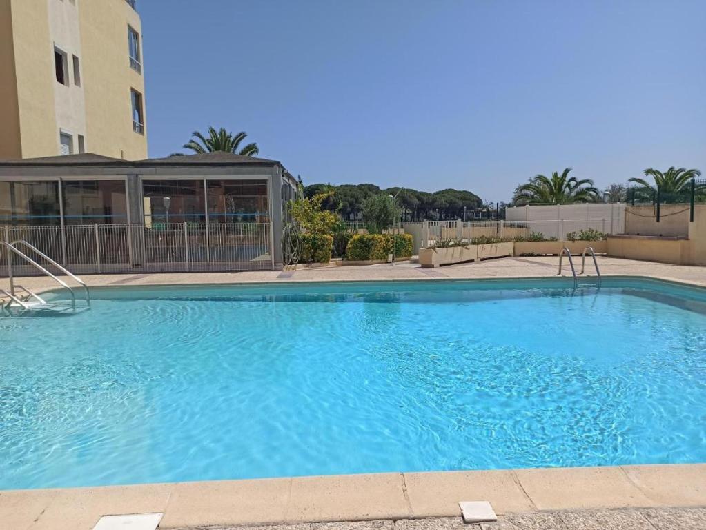 une grande piscine bleue devant un immeuble dans l'établissement Panoramic, Superbe vue lagon pour ce joli studio rénové, au Cap d'Agde